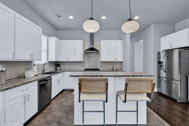 a kitchen with kitchen island granite countertop a sink a center island stainless steel appliances and cabinets