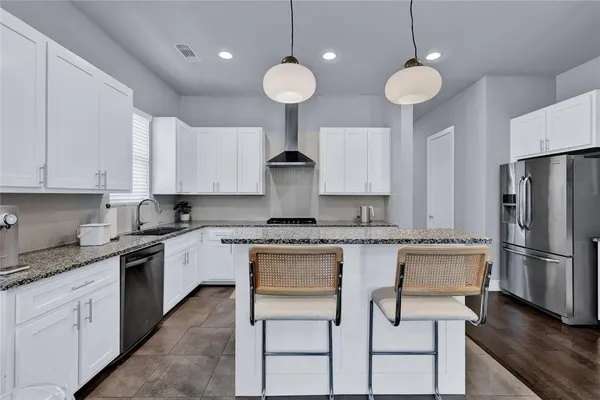 a kitchen with kitchen island granite countertop a sink a center island stainless steel appliances and cabinets