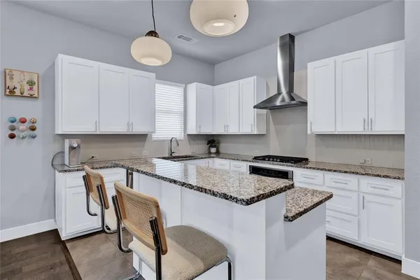 a kitchen with stainless steel appliances granite countertop a sink a stove and a cabinets