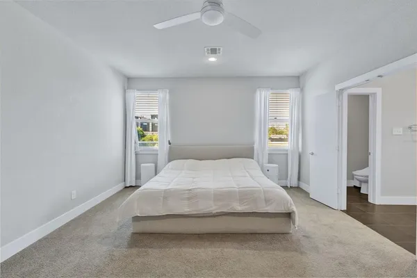 a spacious bedroom with a bed and table