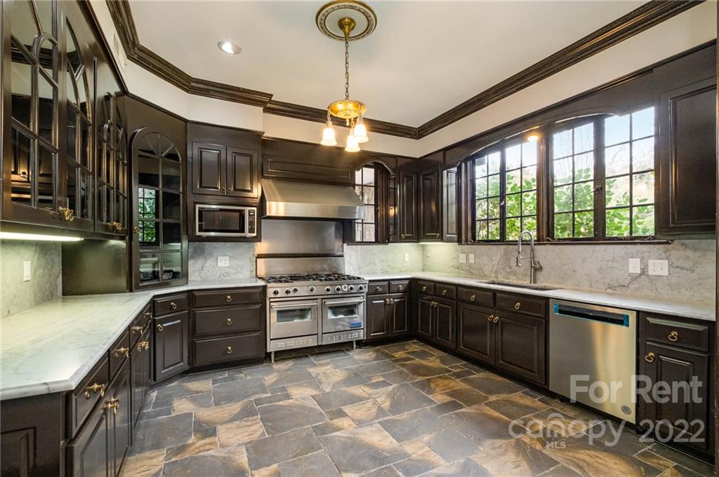 1107 Queens Road Charlotte, NC 28207 - Photo 13 of 44 a large kitchen with stainless steel appliances granite countertop a stove and a sink