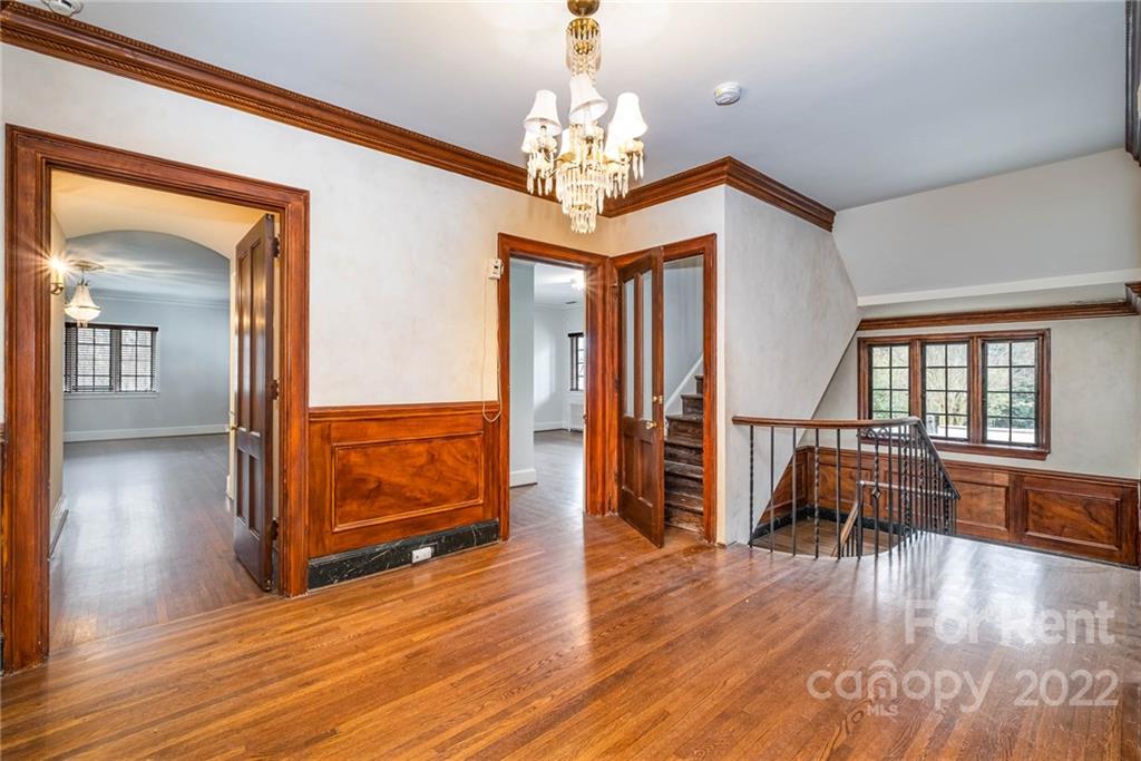 1107 Queens Road Charlotte, NC 28207 - Photo 22 of 44 a view of a livingroom with furniture wooden floor chandelier and windows
