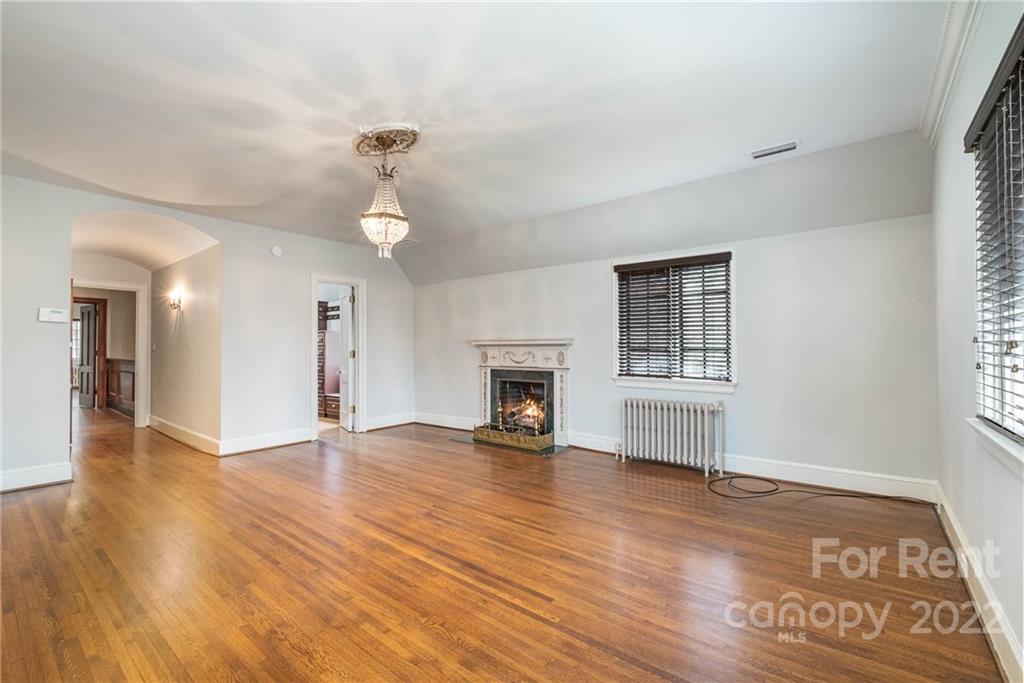 1107 Queens Road Charlotte, NC 28207 - Photo 23 of 44 a view of an empty room with wooden floor fireplace and a window