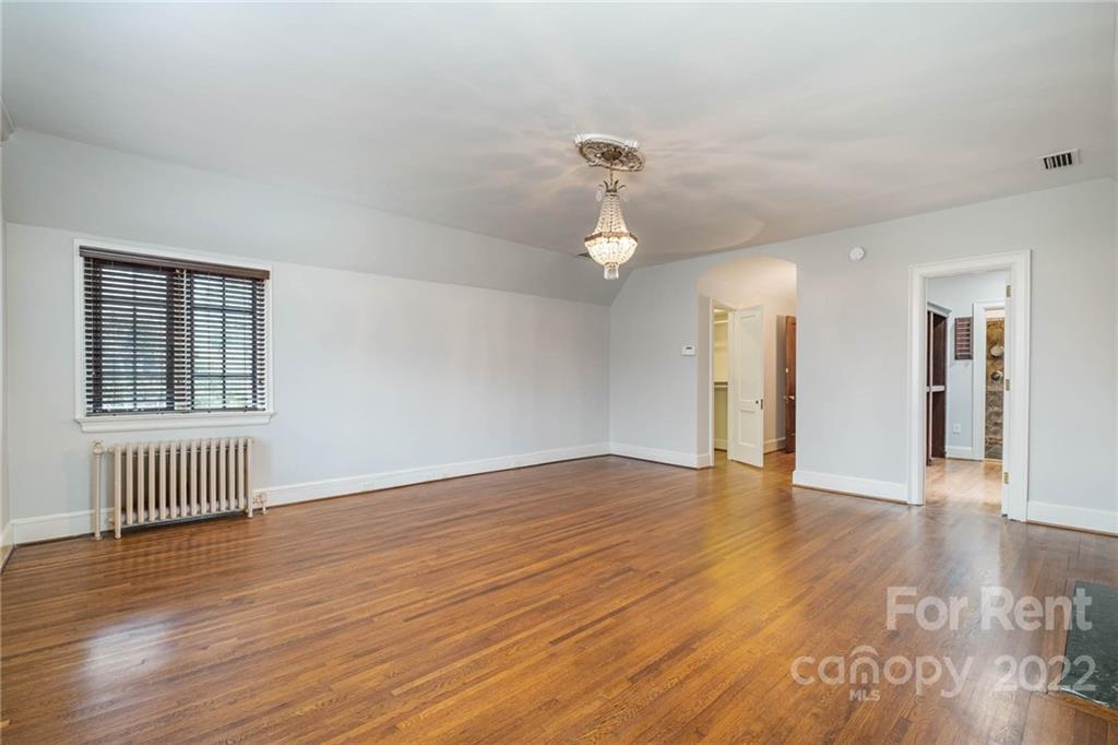 1107 Queens Road Charlotte, NC 28207 - Photo 24 of 44 a view of an empty room with wooden floor and a window