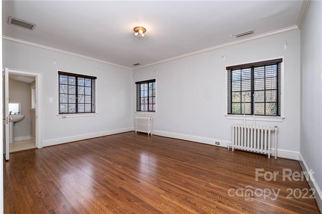 1107 Queens Road Charlotte, NC 28207 - Photo 33 of 44 an empty room with wooden floor and windows
