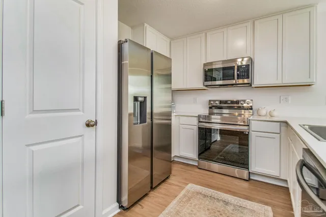 a kitchen with stainless steel appliances granite countertop a refrigerator and a stove top oven