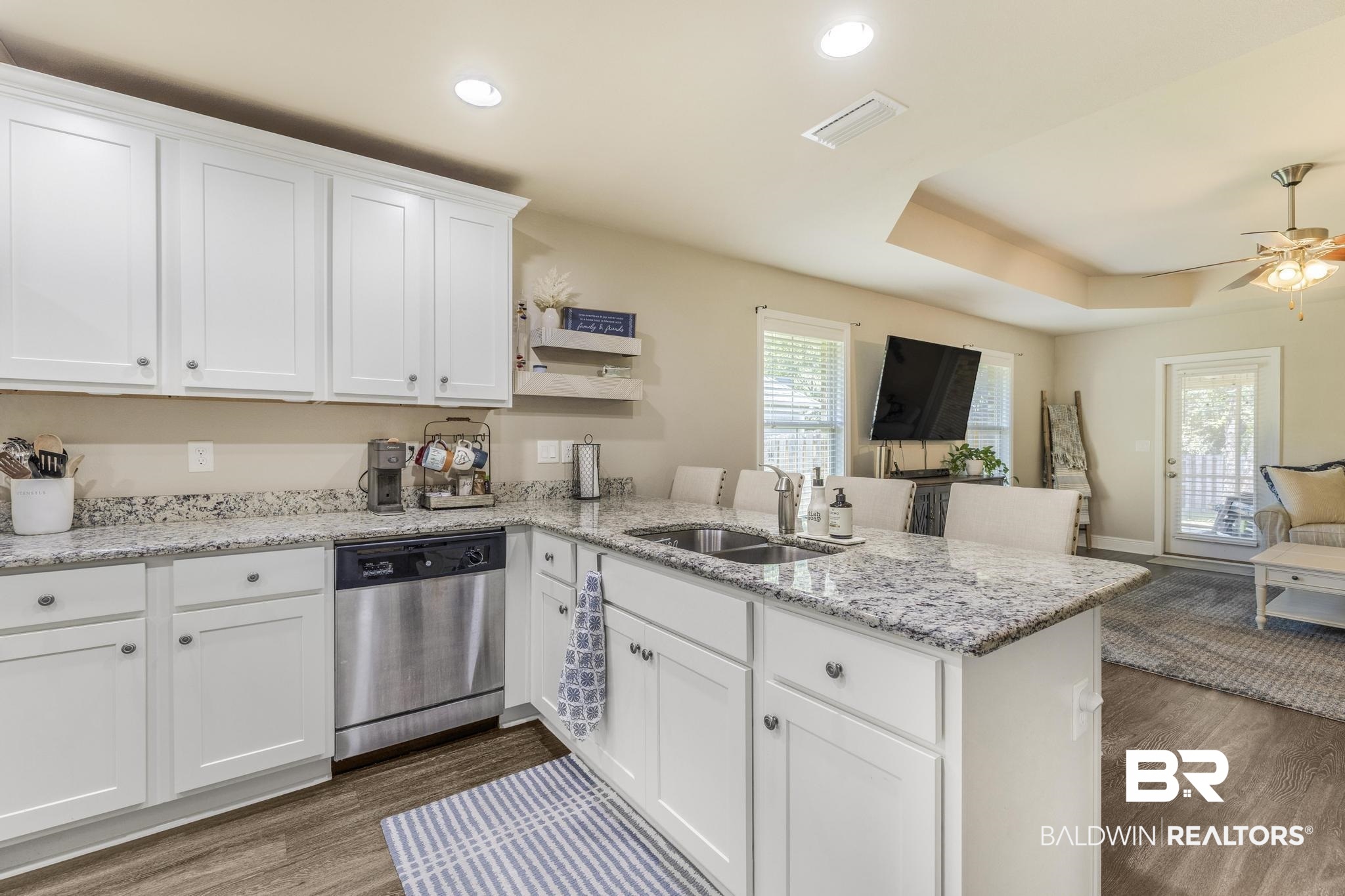 22043 Garland Loop Silverhill, AL 36576 - Photo 39 of 41 Kitchen with a peninsula, open floor plan, light stone countertops, dishwasher, and white cabinetry