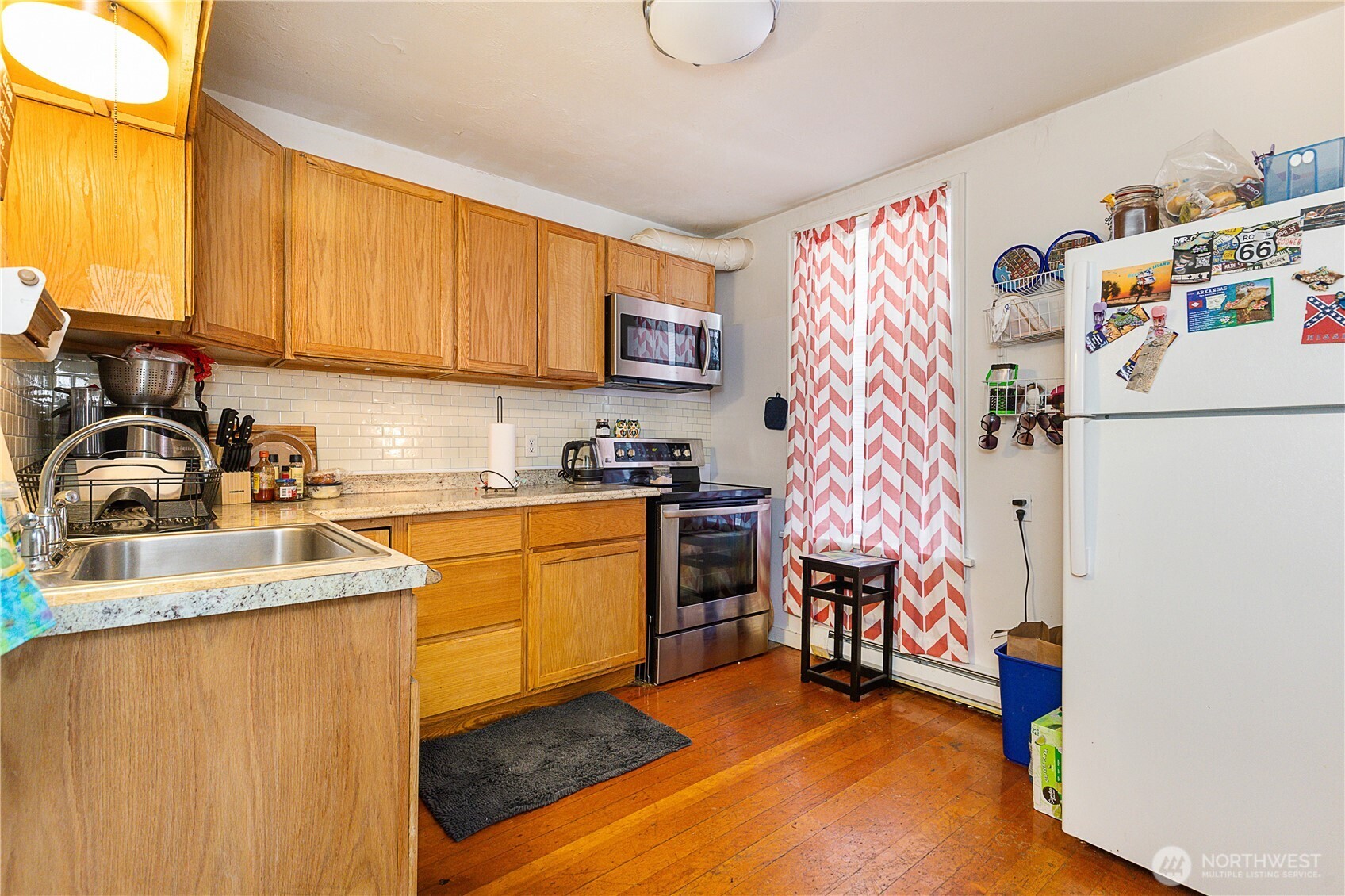 2601 Rucker Avenue Everett, WA 98201 - Photo 22 of 39 a kitchen with stainless steel appliances granite countertop a refrigerator sink and white cabinets