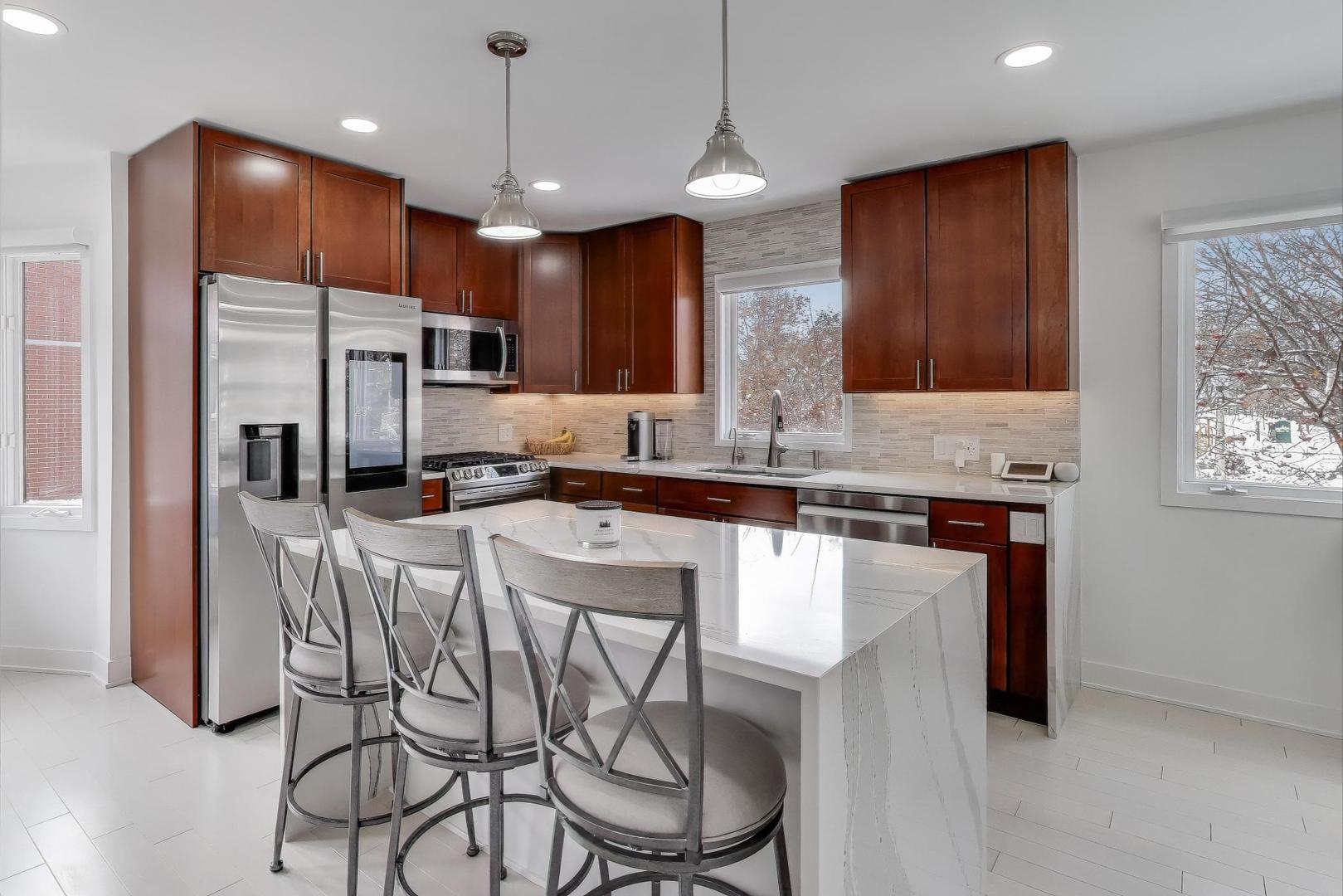 1459 West Wrightwood Avenue, Unit 1459 Chicago, IL 60614 - Photo 14 of 40 a kitchen with stainless steel appliances granite countertop a stove a refrigerator a sink a dining table and chairs with wooden floor