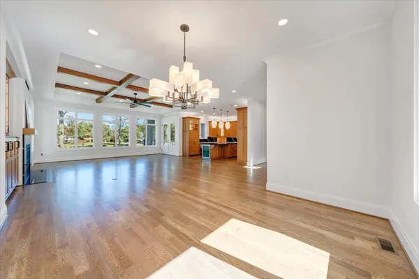 a view of empty room with wooden floor and windows