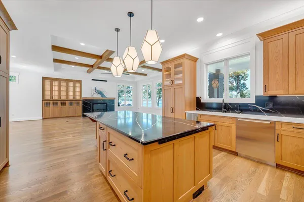 a view of a brick house next to a yard with big trees