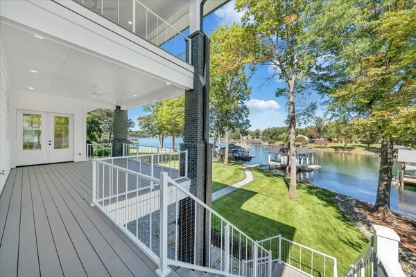 an aerial view of a house with swimming pool and lake view
