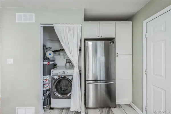 a view of kitchen with stainless steel appliances refrigerator and cabinets