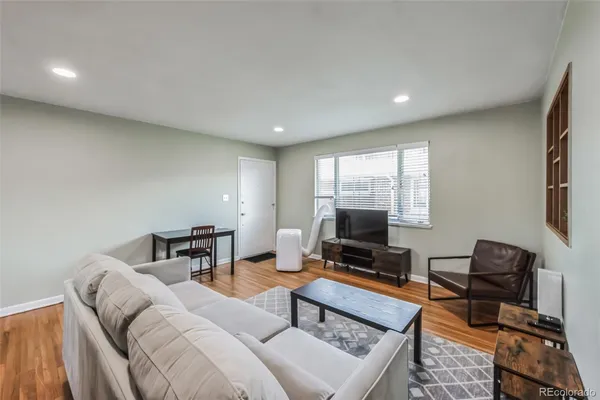 a living room with furniture a flat screen tv and a window