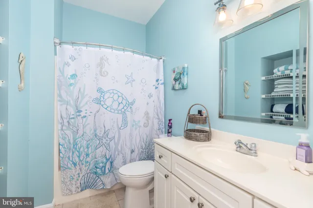 a bathroom with a granite countertop sink a toilet and a shower