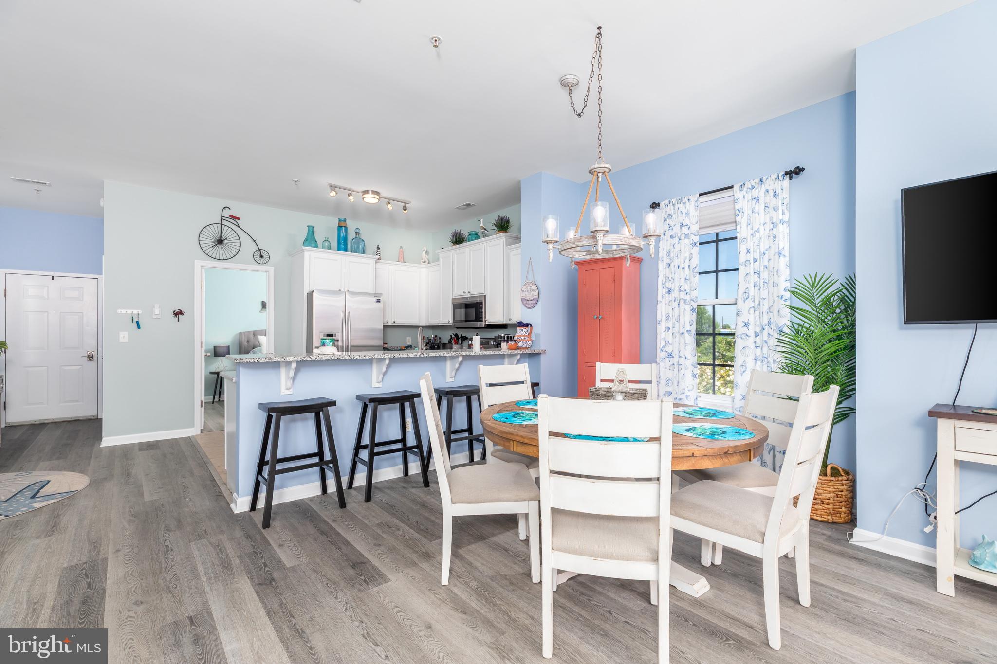 17300 North Village Main Boulevard, Unit 66 Lewes, DE 19958 - Photo 5 of 38 a kitchen with kitchen island a dining table and chairs