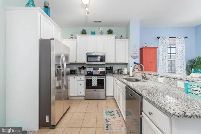 a kitchen with stainless steel appliances granite countertop a refrigerator sink and stove