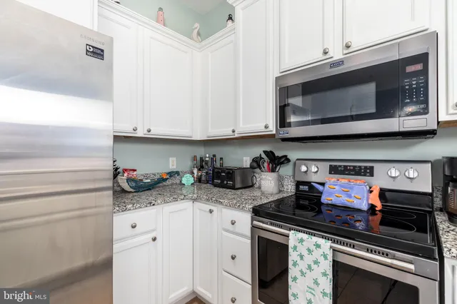 a kitchen with stainless steel appliances granite countertop a stove and a microwave