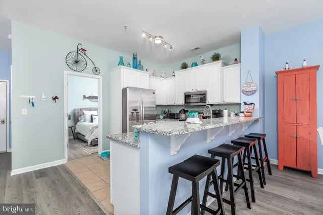 a kitchen with stainless steel appliances granite countertop a refrigerator and microwave
