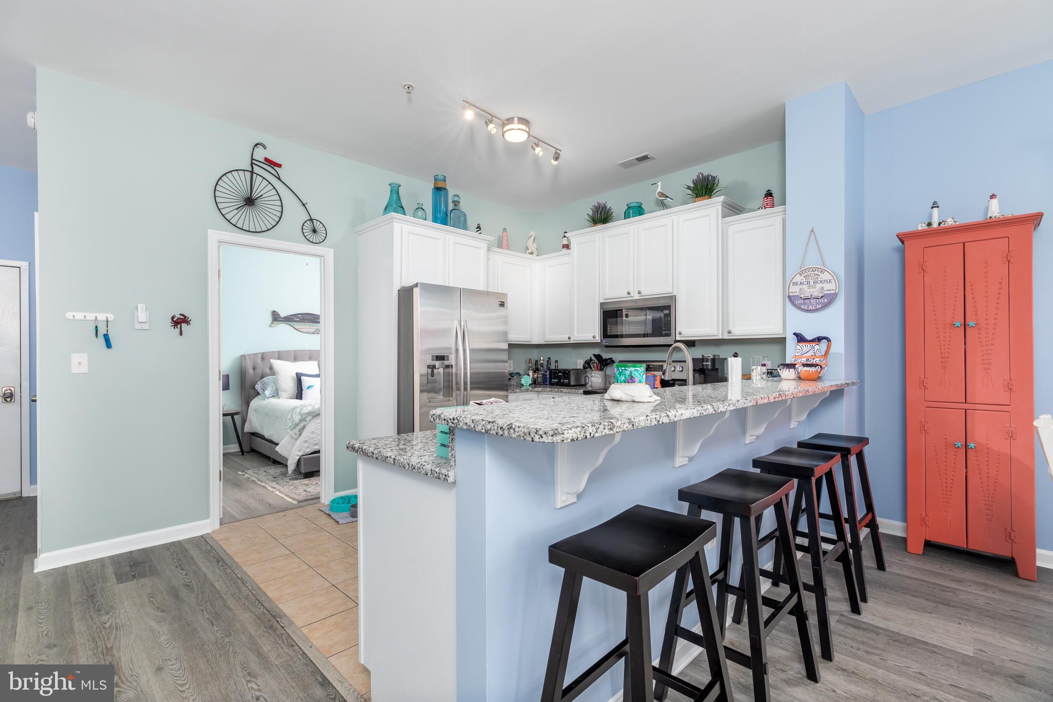 17300 North Village Main Boulevard, Unit 66 Lewes, DE 19958 - Photo 8 of 38 a kitchen with stainless steel appliances granite countertop a refrigerator and microwave