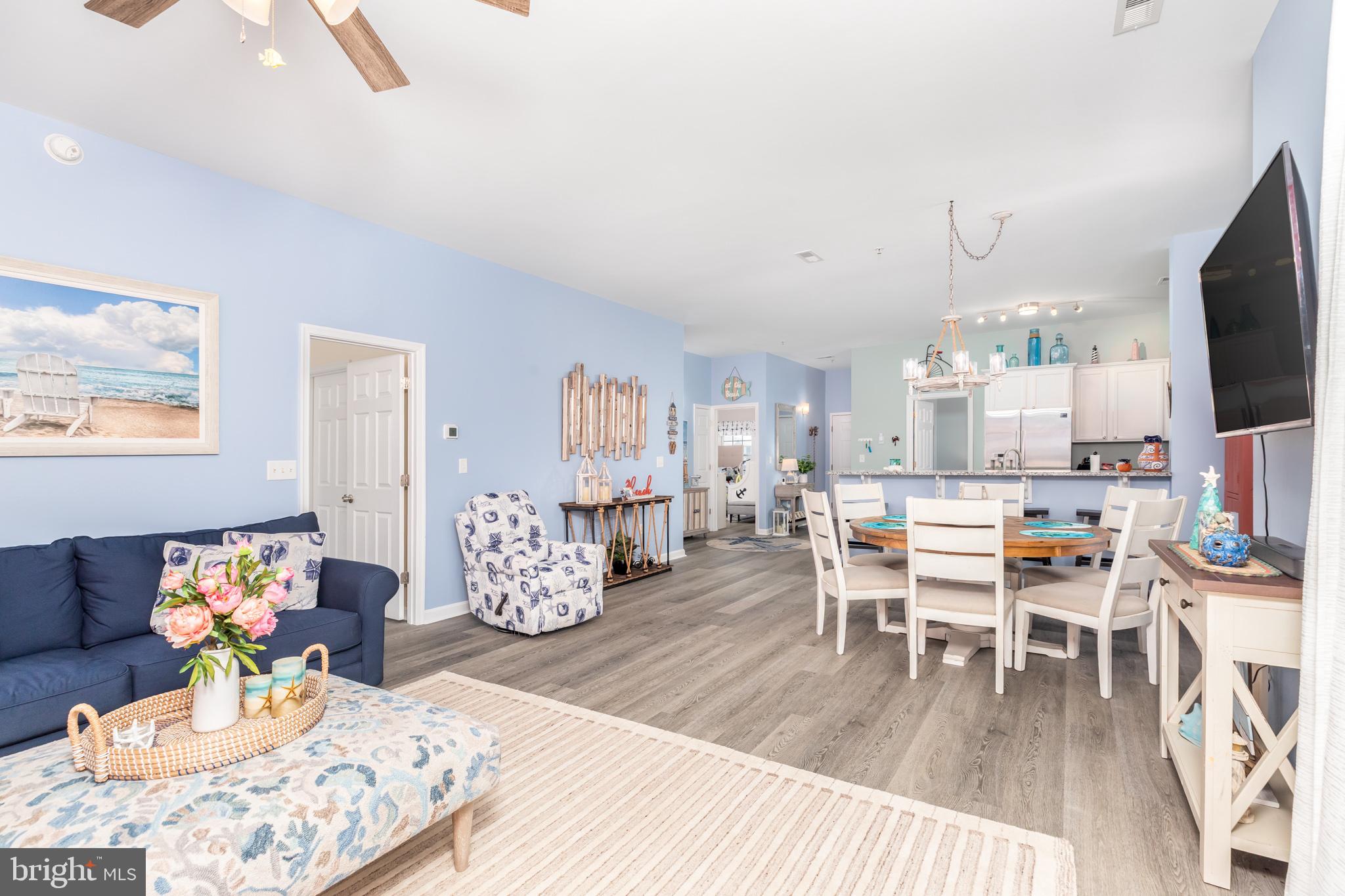 17300 North Village Main Boulevard, Unit 66 Lewes, DE 19958 - Photo 9 of 38 a living room with furniture a flat screen tv and a table