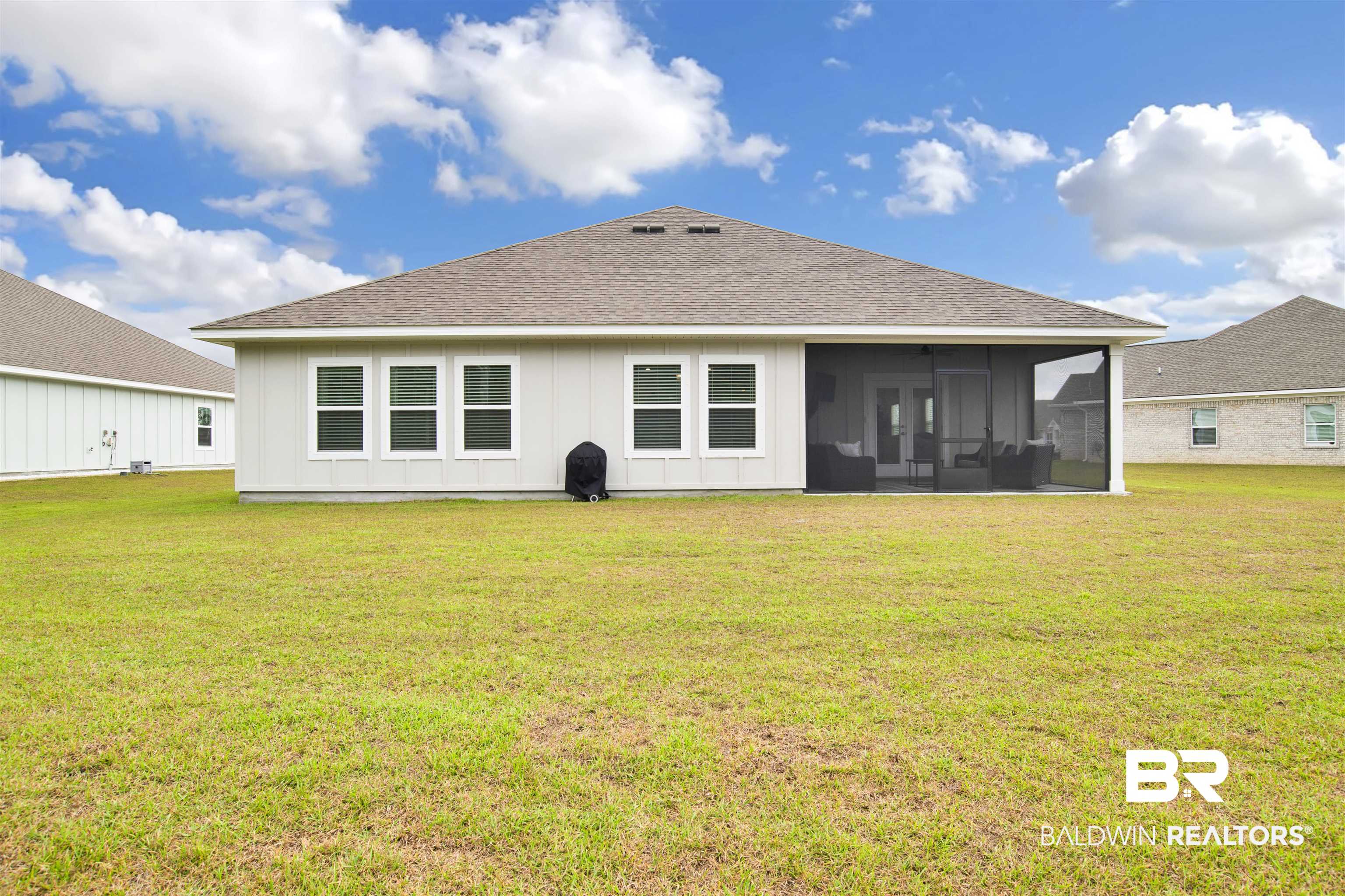 594 Shepard Street Gulf Shores, AL 36542 - Photo 36 of 51 Back of house with a lawn, board and batten siding, roof with shingles, and a sunroom