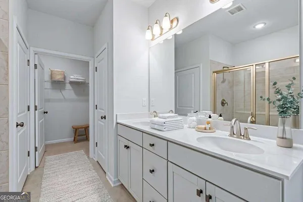 a en suite bathroom with a double vanity sink mirror and shower