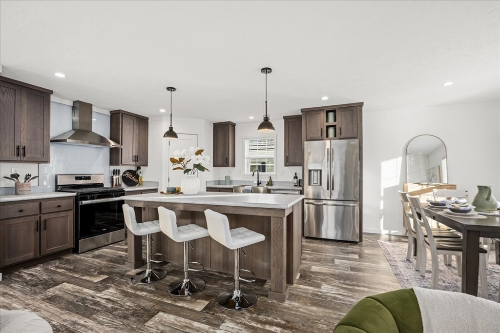 6 Berry Farms Road, Unit 64 Sturbridge, MA 01566 - Photo 7 of 18 a kitchen with a table chairs stove and refrigerator