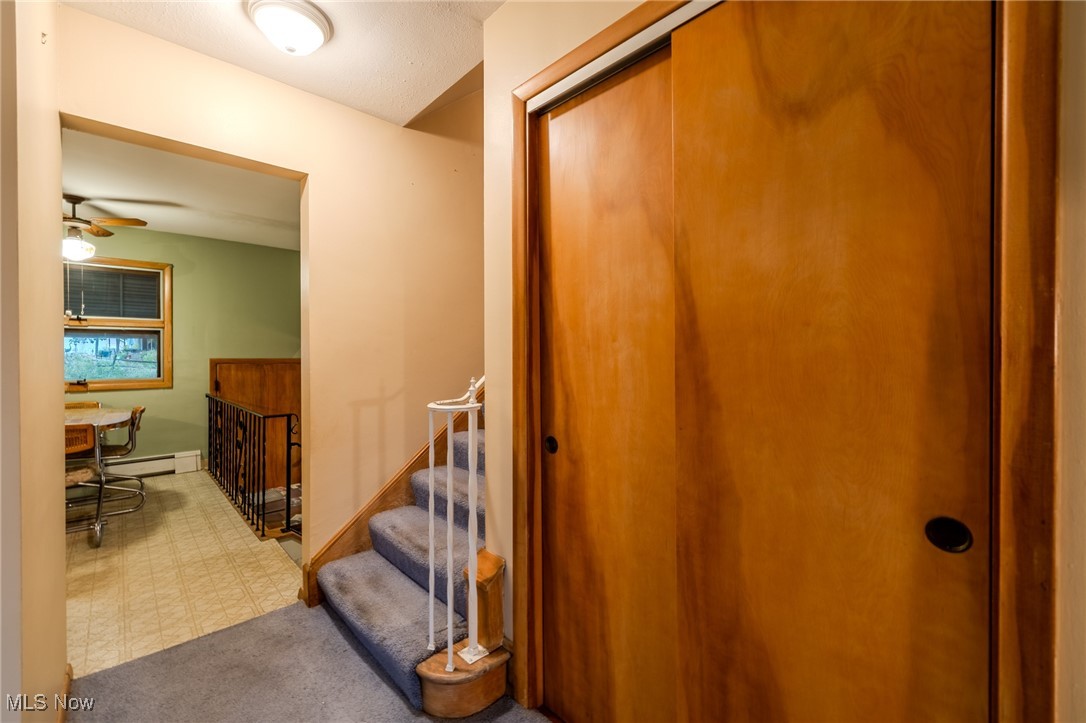 1950 Rush Road Wickliffe, OH 44092 - Photo 23 of 50 Corridor featuring stairway, carpet, a baseboard heating unit, and tile patterned floors