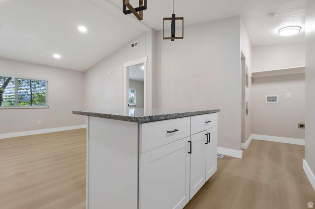 96 Barrington Way Layton, UT 84041 - Photo 3 of 28 Kitchen with lofted ceiling, pendant lighting, light wood-style flooring, white cabinetry, and a kitchen island