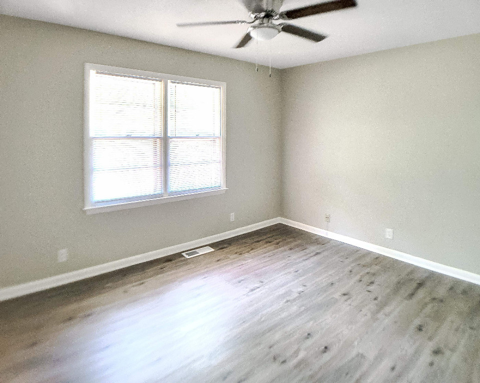 Undisclosed Address Raleigh, NC 27604 - Photo 14 of 32 an empty room with wooden floor and windows