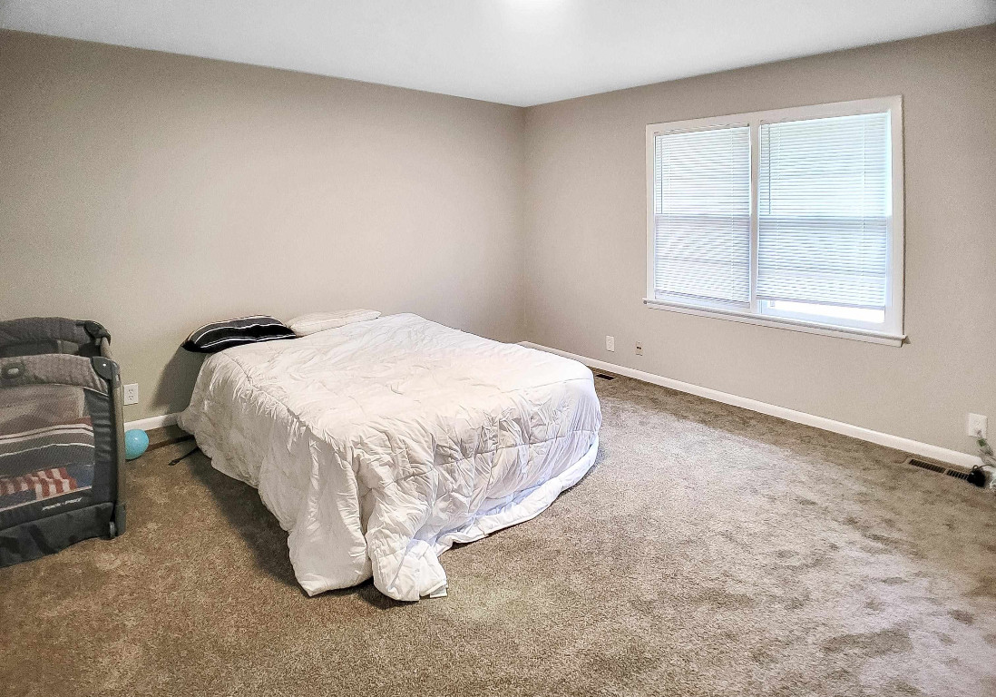 Undisclosed Address Raleigh, NC 27604 - Photo 19 of 32 a bed sitting in a bedroom next to a window