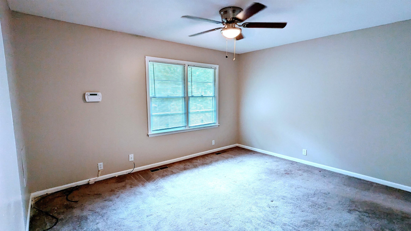 Undisclosed Address Raleigh, NC 27604 - Photo 28 of 32 an empty room with a window and a fan