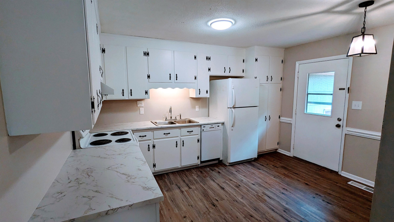 Undisclosed Address Raleigh, NC 27604 - Photo 3 of 32 a kitchen with granite countertop white cabinets and white appliances