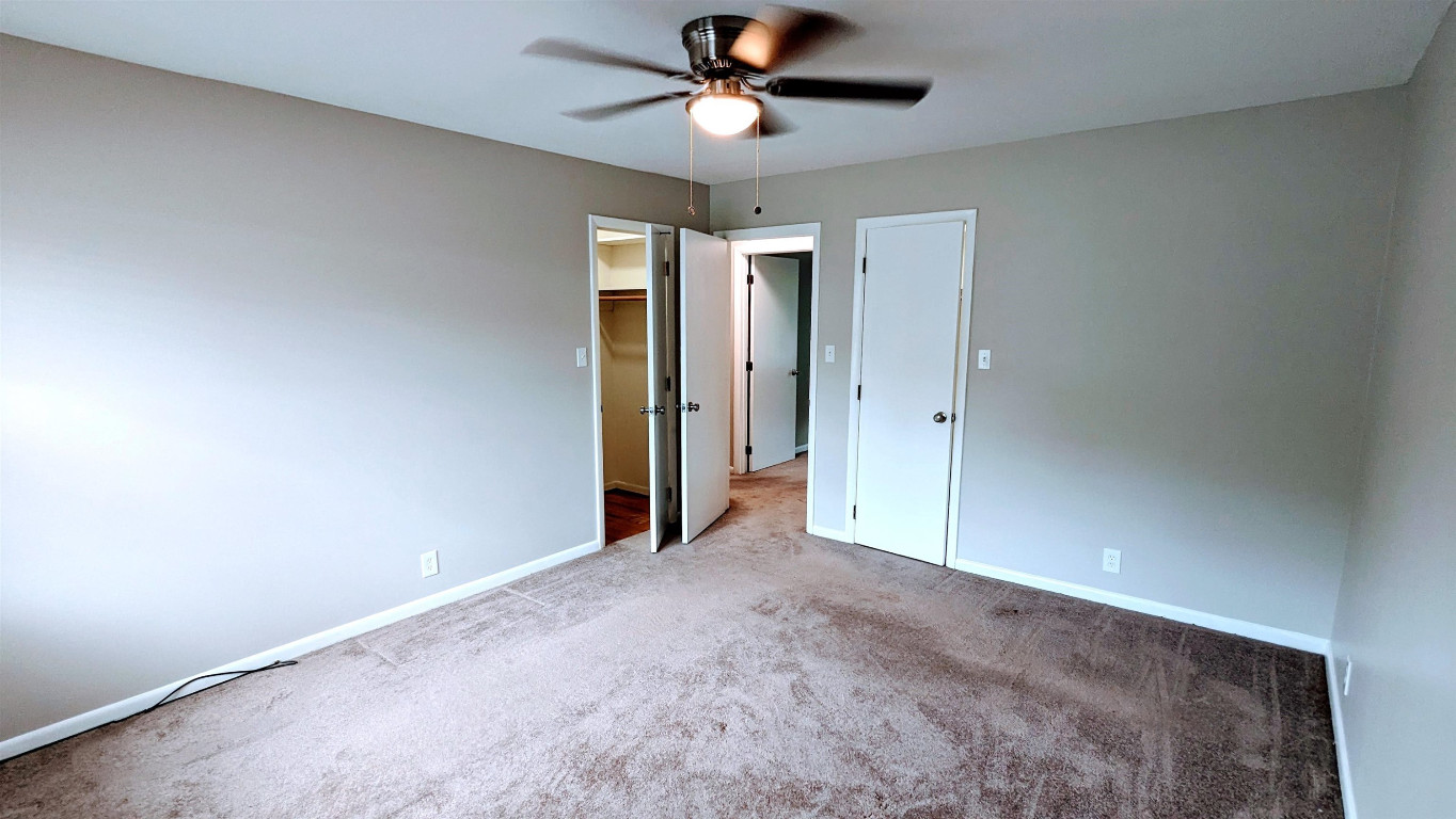 Undisclosed Address Raleigh, NC 27604 - Photo 32 of 32 an empty room with closet and a chandelier fan