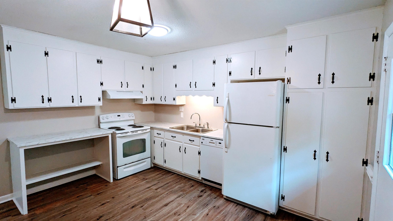 Undisclosed Address Raleigh, NC 27604 - Photo 4 of 32 a kitchen with granite countertop white cabinets and white appliances