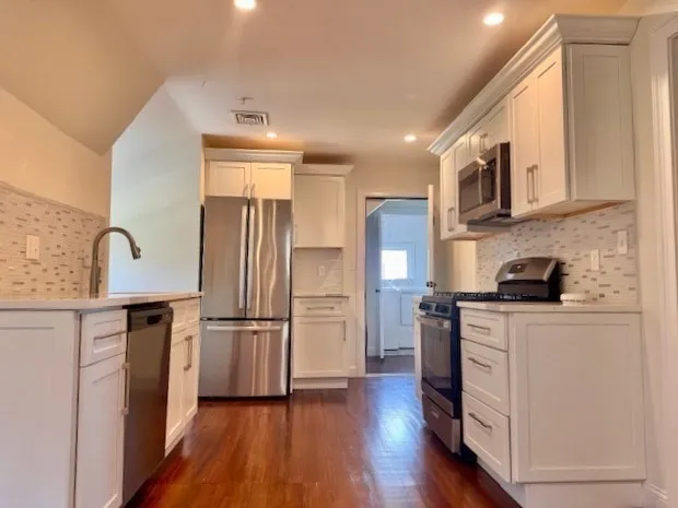 a kitchen with a refrigerator stove and wooden cabinets