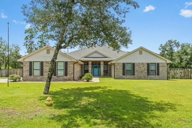 a front view of a house with a yard and trees