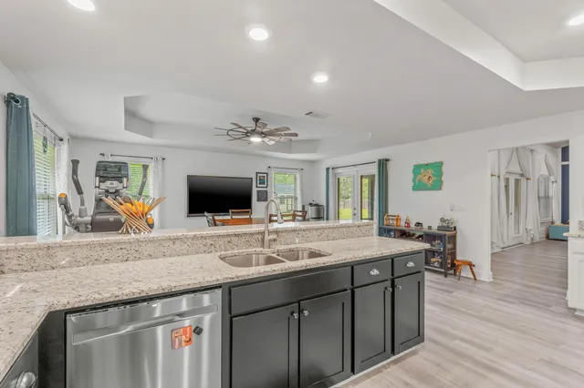 a living room with stainless steel appliances granite countertop furniture a fireplace and a flat screen tv