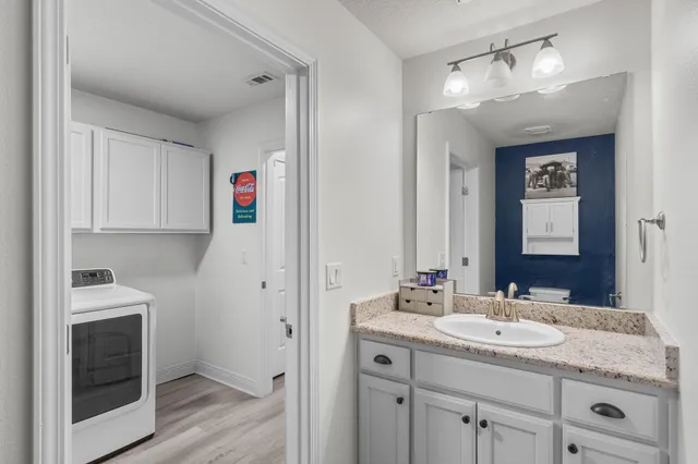 a en suite bathroom with a granite countertop double vanity sink and shower