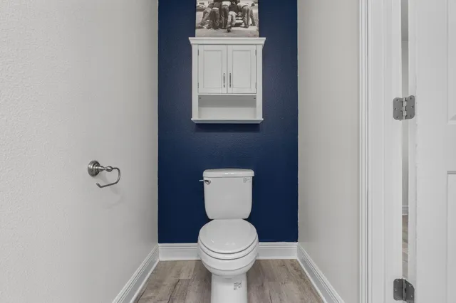 a white toilet sitting in a bathroom next to a sink