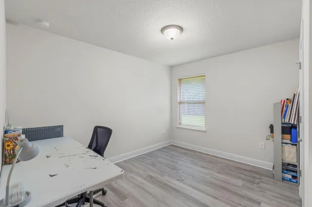 a view of a workspace with furniture and wooden floor