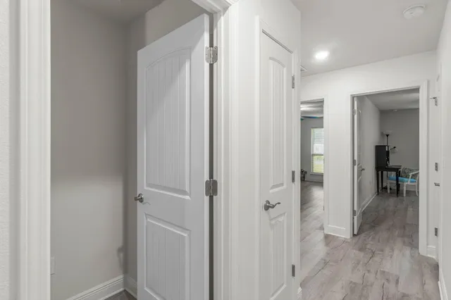 a view of a hallway with closet and wooden floor
