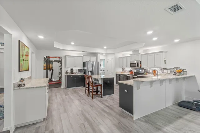 a living room with stainless steel appliances kitchen island granite countertop lots of counter top space and furniture