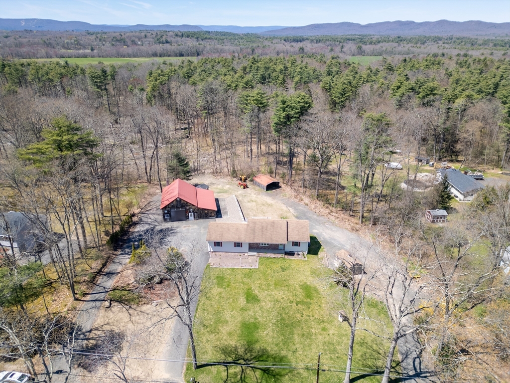 a aerial view of a house with a yard and mountain view