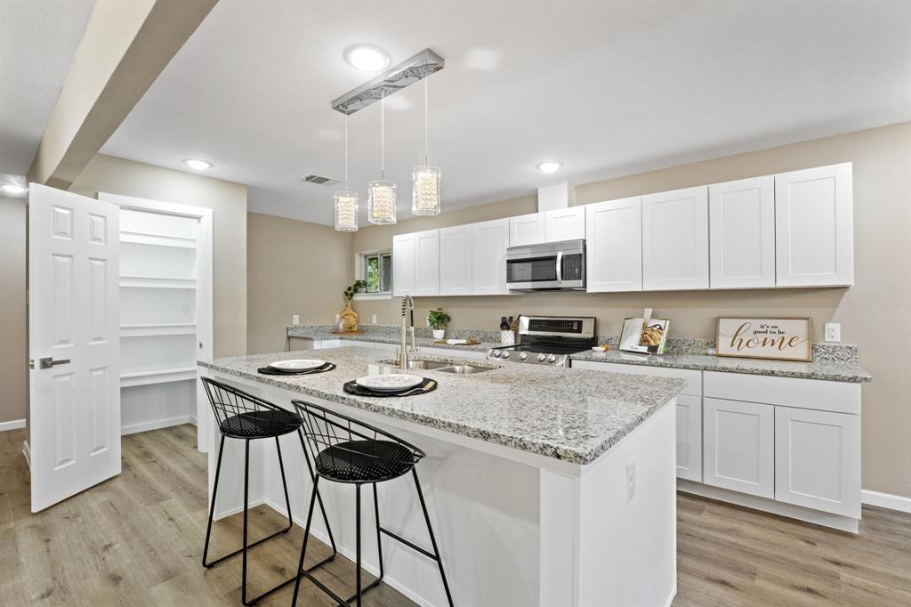 a kitchen with a center island white cabinets and stainless steel appliances