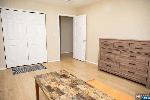 a view of a bedroom with wooden floor and closet