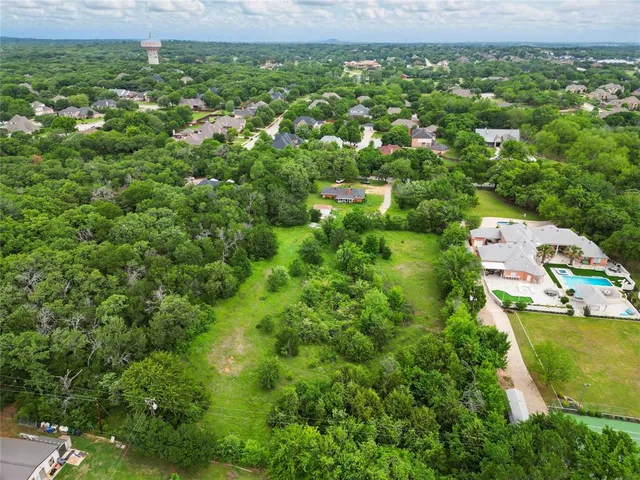 an aerial view of residential houses with outdoor space and trees