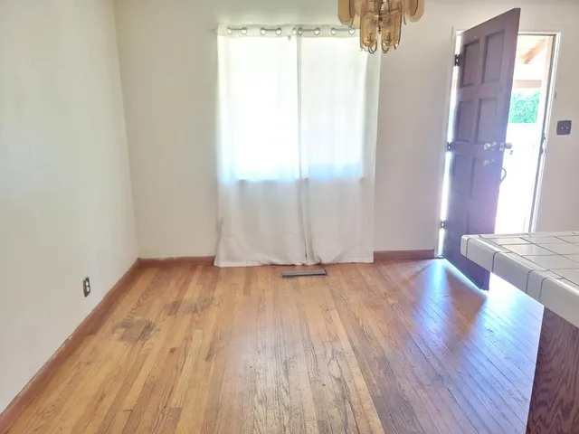 a view of a room with wooden floor and window