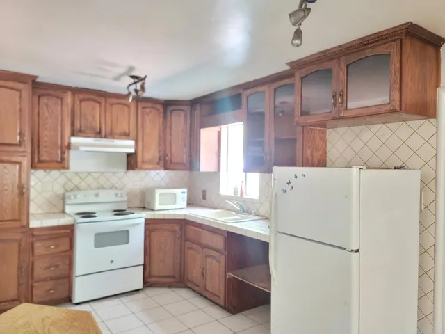 a kitchen with a white stove top oven and refrigerator